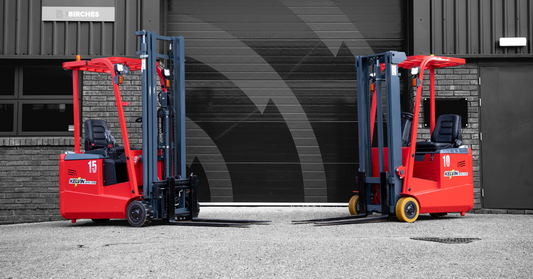 Two red forklifts in-front of a warehouse
