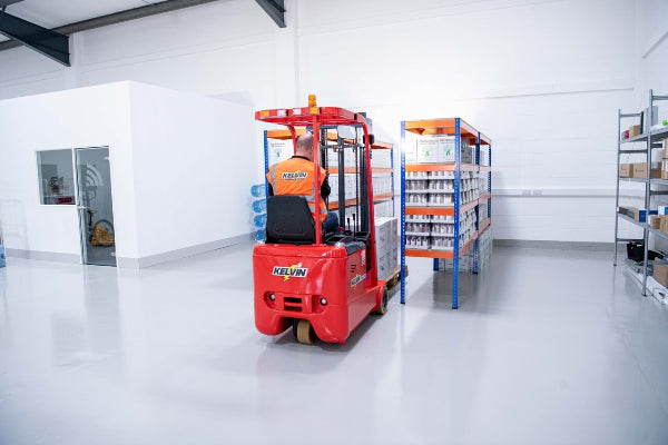 Person operating a red forklift in a warehouse setting