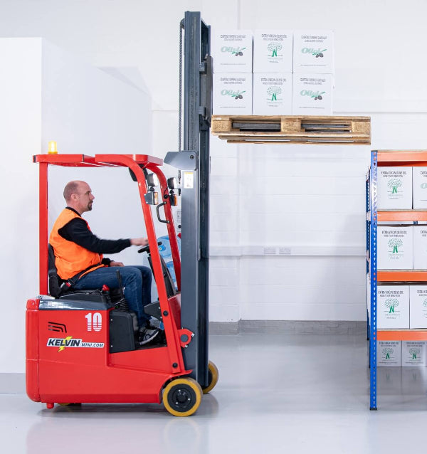 Person operating a red forklift in a warehouse setting with boxes and pallets.